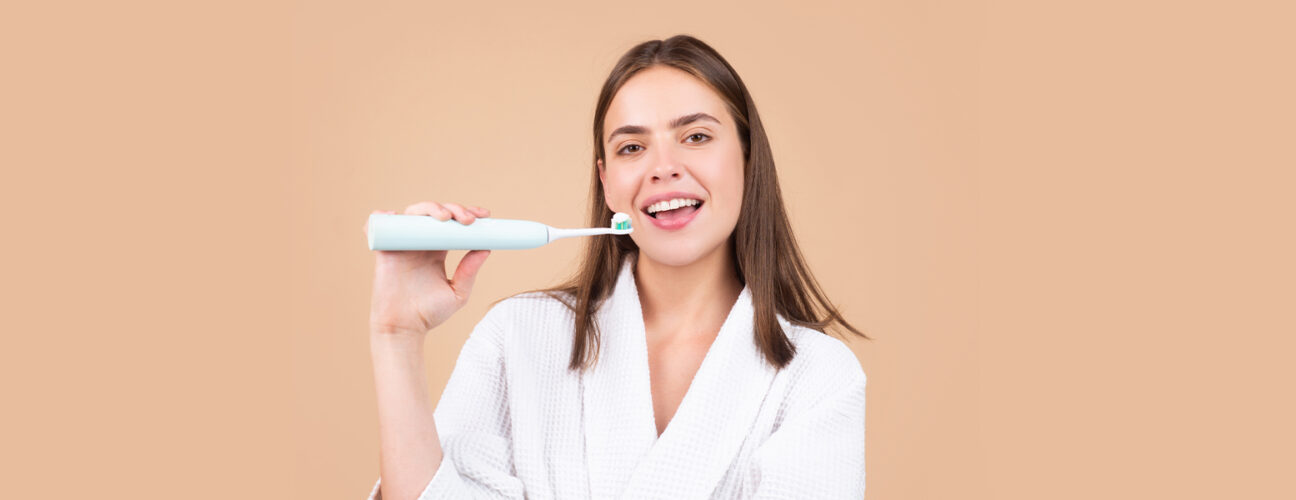Smart girl brushing her teeth with electric brush emphasizing on preventive dentistry in Markham, ON.
