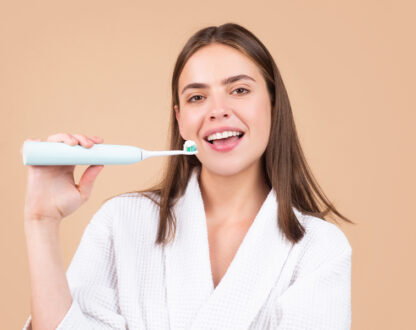 Smart girl brushing her teeth with electric brush emphasizing on preventive dentistry in Markham, ON.