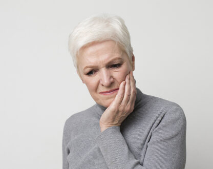A aged lady suffering from tooth pain and looking to visit a dental clinic in Markham, ON.